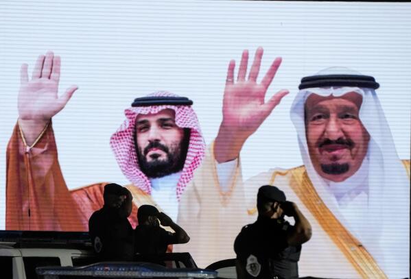 FILE - Saudi special forces salute in front of a screen displaying images Saudi King Salman, right, and Crown Prince Mohammed bin Salman after a military parade in preparation for the annual Hajj pilgrimage, in the Muslim holy city of Mecca, Saudi Arabia, July 3, 2022. President Joe Biden will become the first U.S. president to travel directly from Israel to Saudi Arabia. The world will be watching the highly anticipated meeting Friday to see if the gaffe-prone U.S. president and notoriously vengeful Saudi prince can begin repairing a rift between the two strategic partner. (AP Photo/Amr Nabil, File)