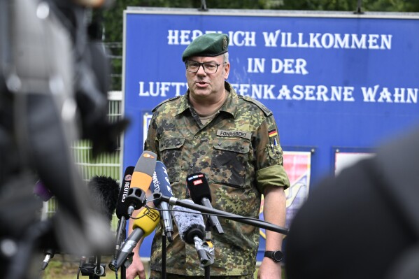 Lieutenant Colonel Ulrich Fonrobert from the North Rhine-Westphalia State Command speaks to reporters about the events at the air force barracks in Wahn outside Cologne, Germany, Wednesday Aug. 14, 2024. (Roberto Pfeil/dpa via AP)