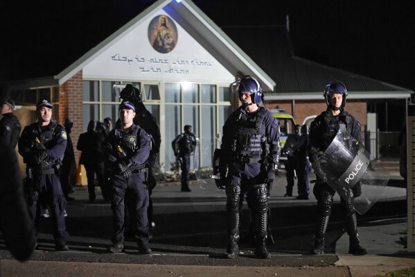 Security officers stand guard outside the Assyrian Orthodox Church in Sydney, Australia, Monday, April 15, 2024. Police in Australia say a man has been arrested after a bishop and parishioners were stabbed inside the church.  There is no danger to life.  (AP Photo/Mark Baker)