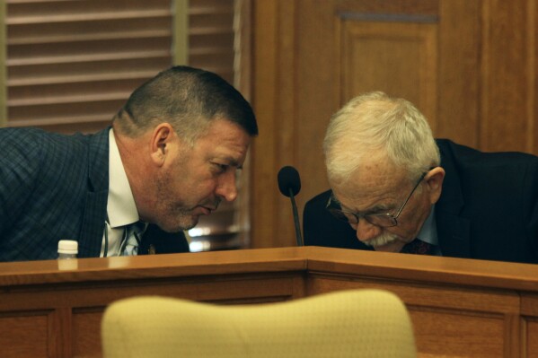 Kansas state Sen. Rick Kloos, R-Topeka, confers with Mike Heim, a member of the Legislature's legal staff, during negotiations between the House and the Senate over elections legislation, Monday, April 1, 2024, at the Statehouse in Topeka, Kan. Republicans are pushing to end the extra three days given to voters to return mail ballots, calling it a move that will increase confidence in election results. (AP Photo/John Hanna)