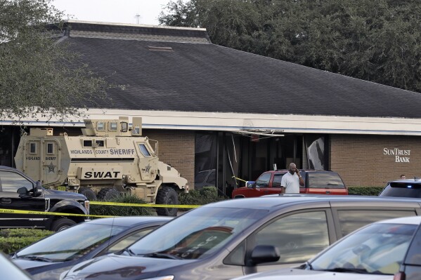 FILE - A Highlands County Sheriff's SWAT vehicle is stationed out in front of a SunTrust Bank branch, Wednesday, Jan. 23, 2019, in Sebring, Fla., where authorities say five people were shot and killed. Jury selection starts Monday in the penalty trial of 27-year-old Zephen Xaver, who pleaded guilty last year to the murders. (AP Photo/Chris O'Meara, File)