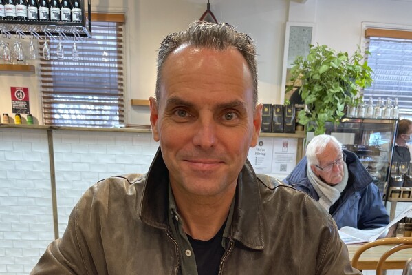 In this undated photo provided by Saffrine Duggan, her husband Daniel Duggan poses for a photo in a restaurant. A lawyer for former U.S. military pilot, Duggan, accused of illegally training Chinese aviators, has told a Sydney court on Wednesday, Oct. 4, 2023, that an extradition hearing scheduled for next month needs to be postponed due to delays in government agencies handing over crucial material. (Saffrine Duggan via AP)