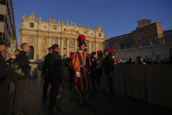 Faithful and Swiss Guards are backdropped by St. Peter's Basilica ahead of the funeral of Pope Francis in St. Peter's Square at the Vatican, Saturday, April 26, 2025. (AP Photo/Alessandra Tarantino)