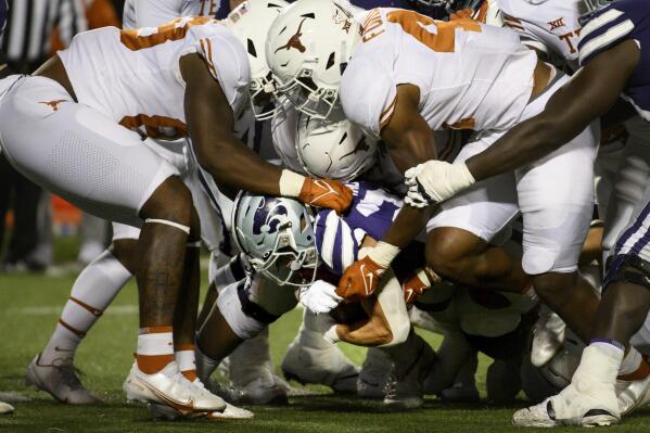 Kansas State running back Deuce Vaughn (22) is tackled by Texas defenders during the first half of an NCAA college football game Saturday, Nov. 5, 2022, in Manhattan, Kan. (AP Photo/Reed Hoffmann)