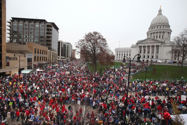 FILE - Protesters gather for the "We Are Wisconsin" rally and petition signing for the recall of then-Gov. Scott Walker, Nov. 19, 2011, at the state Capitol in Madison, Wis. A judge overseeing a challenge brought by unions trying to undo Wisconsin’s law that bans nearly all collective bargaining for public workers appears to have signed a petition in 2011 to recall then-Gov. Scott Walker from office because of anger over that law. (Rick Wood/Milwaukee Journal-Sentinel via AP, File)