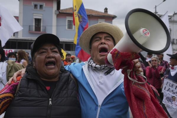 People shout in favor of the impeachment of President Guillermo Lasso, accused of alleged embezzlement of state funds, outside the National Assembly where lawmakers are debating to continue the legal process in Quito, Ecuador, Tuesday, May 9, 2023. (AP Photo/Dolores Ochoa)