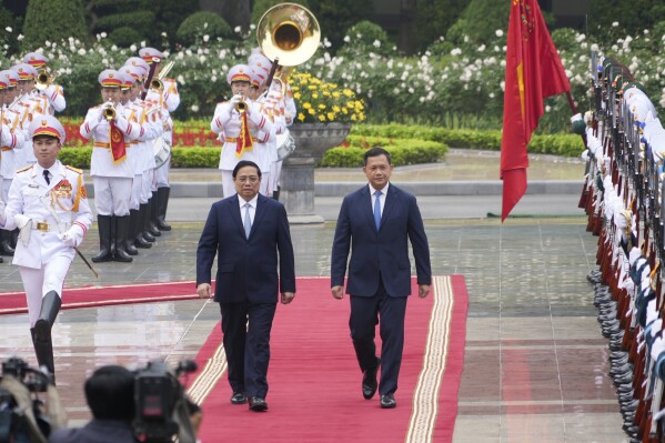Vietnamese Prime Minister Pham Minh Chinh, left, and Cambodian Prime Minister Hun Manet inspect honor guards in Hanoi, Vietnam on Monday, Dec.11, 2023. Manet is on a visit to Hanoi to boost the bilateral relation between the two Southeast Asian nations. (AP Photo/Hau Dinh)