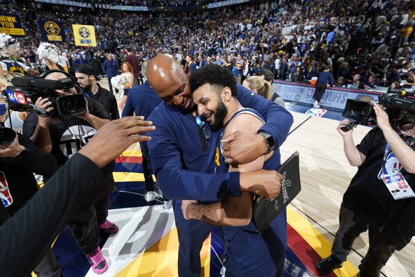 Denver Nuggets assistant coach Popeye Jones, left, hugs guard Jamal Murray after Game 5 of an NBA basketball first-round playoff series against the Los Angeles Lakers Monday, April 29, 2024, in Denver. Murray scored 32 points despite a strained calf and sank the game-winner with 3.6 seconds left to win over the Lakers. (AP Photo/David Zalubowski)