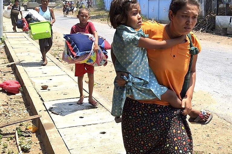 In this photo released by the Free Burma Rangers, families flee after a Buddhist monastery sheltering civilians displaced by fighting in the town of Papun, Karen state, Myanmar was attacked on March 31, 2024 by a regime warplane. (Free Burma Rangers via AP)