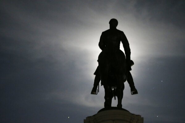 The Moon illuminates the statue of Confederate General Robert E. Lee on Monument Avenue Friday June 5, 2020, in Richmond, Va. Virginia Gov. Ralph Northam has ordered the removal of the statue. (AP Photo/Steve Helber)