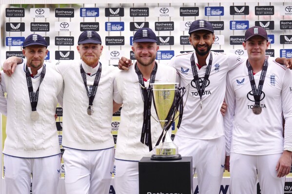 From left, England's Joe Root, Ben Stokes, Sam Cook, Shoaib Bashir and Jamie Smith stand with the trophy after winning the Rothesay International test match at Trent Bridge, Nottingham, England, Saturday, May 24, 2025. (Mike Egerton/PA via AP)