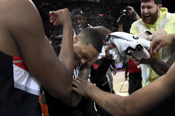 Portland Trail Blazers guard Damian Lillard, center, is doused by teammates after setting franchise and career highs with 71 points during an NBA basketball game against the Houston Rockets in Portland, Ore., Sunday, Feb. 26, 2023. (AP Photo/Steve Dykes)
