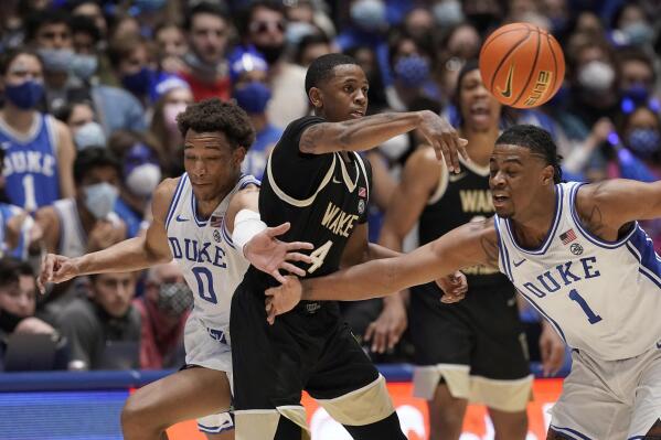 Wake Forest guard Daivien Williamson (4) passes while Duke forward Wendell Moore Jr. (0) and guard Trevor Keels (1) defend during the second half of an NCAA college basketball game in Durham, N.C., Tuesday, Feb. 15, 2022. (AP Photo/Gerry Broome)