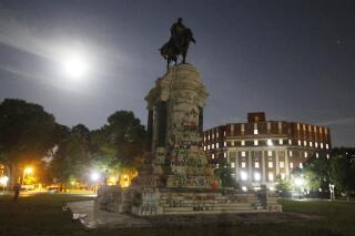 The moon illuminates the statue of Confederate General Robert E. Lee on Monument Avenue Friday June. 5, 2020, in Richmond, Va. The Supreme Court of Virginia ruled Thursday, Sept 2, 2021 that the state can take down an enormous statue that has towered over Monument Avenue in the state’s capital for more than a century and has become a symbol of racial injustice. (AP Photo/Steve Helber, file)