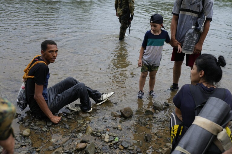 A Venezuelan migrant with a broken ankle rests on the Tuquesa river´s edge after trekking for two days through the Darien Gap and making it to Bajo Chiquito, Panama, Wednesday, Oct. 4, 2023. The man who did not want to give his name says he was helped by other migrants as he hobbled along the route with the help of a stick, and by the “adrenaline” of making it through the jungle. (AP Photo/Arnulfo Franco)