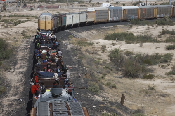Migrants travel on a freight train, arriving in Ciudad Juarez, Mexico, Thursday, Sept. 28, 2023. (AP Photo/Christian Chavez)