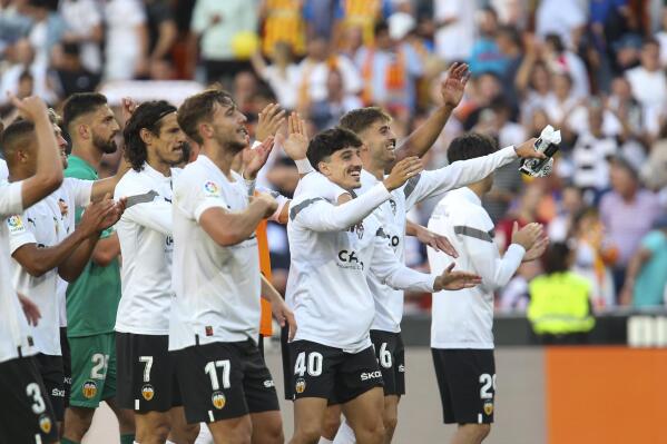 Valencia players celebrate at the end of a Spanish La Liga soccer match between Valencia and Real Madrid, at the Mestalla stadium in Valencia, Spain, Sunday, May 21, 2023. (AP Photo/Alberto Saiz)