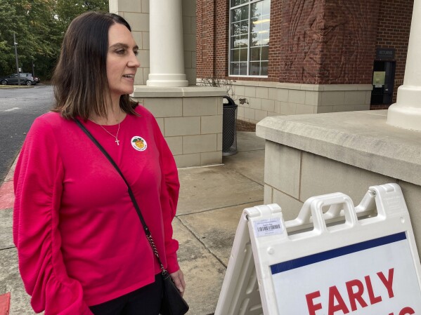 Stacy Skinner, a city councilwoman in John's Creek, Georgia, leaves her early voting location after casting her ballot for her reelection on Oct. 19, 2023. Skinner has accepted an endorsement from Veterans for Trump. But she's careful about how she uses it. The dynamics show how national political fault lines are filtering down to local government and campaigns. (AP Photo/Bill Barrow)