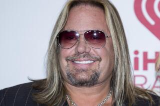 FILE - In this Sept. 19, 2014, file photo, Vince Neil of Motley Crue, arrives at the iHeart Radio Music Festival in Las Vegas.  Neil has broken ribs during a fall off the stage at a concert in Tennessee. In video footage from the performance Friday, Oct. 15, 2021,  Neil can be seen clapping at the edge of the stage with his guitar strapped around him before his fall.   (Photo by Andrew Estey/Invision/AP, File)