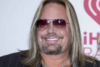 FILE - In this Sept. 19, 2014, file photo, Vince Neil of Motley Crue, arrives at the iHeart Radio Music Festival in Las Vegas. Neil has broken ribs during a fall off the stage at a concert in Tennessee. In video footage from the performance Friday, Oct. 15, 2021, Neil can be seen clapping at the edge of the stage with his guitar strapped around him before his fall. (Photo by Andrew Estey/Invision/AP, File)