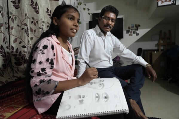 Gautam Dongre, right, of the National Alliance of Sickle Cell Organizations, sits with his daughter, Sumedha, a patient of sickle cell disease, at their residence in Nagpur, India, Wednesday, Dec. 6, 2023. In July, Prime Minister Narendra Modi launched a sickle cell “elimination mission” that combines awareness, education, screening, early detection and treatment. Dongre lauded the effort but said the country faces huge obstacles to meet its goals. (AP Photo/Ajit Solanki)