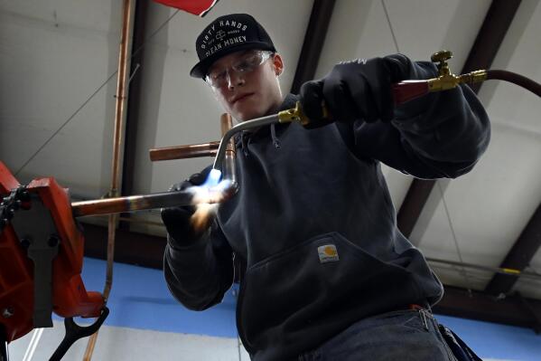 Boone Willams, 20, left, brazes a copper pipe during a second-year apprentice training program class at the Plumbers and Pipefitters Local Union 572 facility in Nashville, Tenn., on Thursday, Feb. 2, 2023. Before the pandemic, Williams was the type of student colleges compete for. He took advanced classes and got A's. He grew up around agriculture and thought about going to college for animal science. (AP Photo/Mark Zaleski)