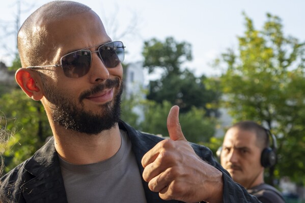 FILE - Andrew Tate gives a thumbs up upon exiting the Court of Appeal in Bucharest, Romania, on July 6, 2023. Andrew Tate, the divisive internet influencer who is charged in Romania with rape, human trafficking, and forming a criminal gang to sexually exploit women, won an appeal on Friday Aug. 4, 2023 to be released from house arrest and will instead be put under judicial control measures, his spokesperson said. (AP Photo/Andreea Alexandru, File)