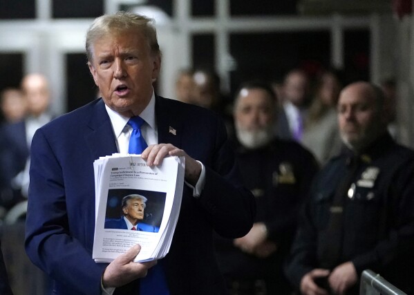 Former President Donald Trump holds up news clippings as he speaks following his trial at Manhattan criminal court in New York on Thursday, April 18, 2024. (Timothy A. Clary/Pool Photo via AP)