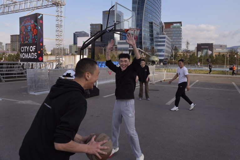 Children play basketball at a city square in Ulaanbaatar, the capital of Mongolia, Sunday, May 21, 2023. (AP Photo/Manish Swarup)