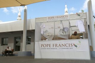 FILE - In this Jan. 20, 2019, file photo, a man sells memorabilia for Pope Francis' upcoming trip to the United Arab Emirates at St. Mary's Catholic Church in Dubai, United Arab Emirates. The United Arab Emirates has branded a bridge, a new ministry, a family day at the park and even the entire year of 2019 under the banner theme of “tolerance”, an elaborate effort that’s in overdrive as the country prepares to host Pope Francis starting Sunday, Feb. 3, 2019 in the first-ever papal visit to the Arabian Peninsula. (AP Photo/Jon Gambrell, File)