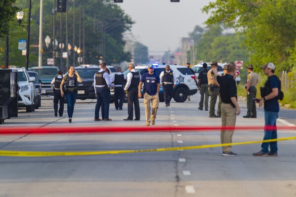 FILE - Chicago police and ATF agents work the scene of a shooting on South Ashland Avenue near West 118th Street next to Interstate 57, July 7, 2021, in Chicago. Police said three undercover law enforcement officers were shot and wounded while driving onto an expressway on Chicago's South Side. Eugene “Gen Gen” McLaurin, of Chicago, pleaded guilty Tuesday, Dec. 5, 2023, to charges in the 2021 drive-by shooting of three undercover law enforcement officers that he mistook for rival gang members, federal prosecutors announced Wednesday, Dec. 6. (Vashon Jordan Jr./Chicago Tribune via AP, File)