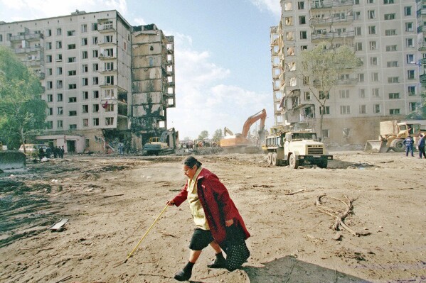 FILE - A local resident passes the apartment building destroyed the day before, by an explosion in Moscow, Friday, Sept. 10, 1999. The attack on a Moscow concert hall in which armed men opened fire and set the building ablaze, killing over 130 people, was the latest in a long series of bombings and sieges that have unsettled and outraged Russians during Vladimir Putin’s nearly quarter-century as either prime minister or president. (AP Photo/Misha Japaridze, File)