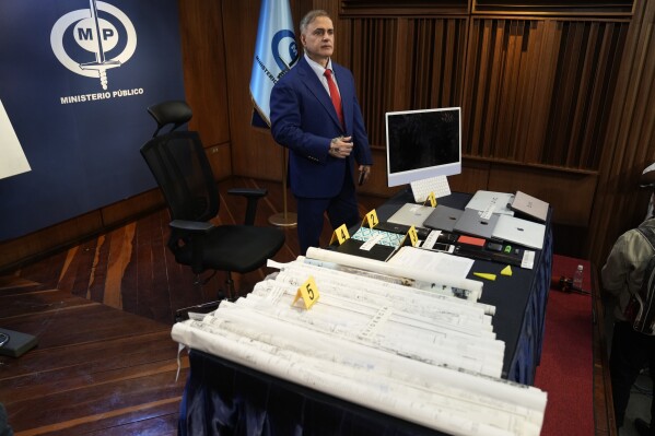 General Attorney Tarek William Saab stands over items he presents as evidence related to the arrest of human rights lawyer and activist Rocio San Miguel, accused of allegedly plotting to kill President Nicolas Maduro in Caracas, Venezuela, Monday, Feb. 19, 2024. (AP Photo/Ariana Cubillos)