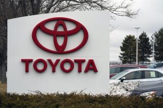 FILE - In this Sunday, March 21, 2021 file photo, The company logo adorns a sign outside a Toyota dealership in Lakewood, Colo. Toyota announced Tuesday, Feb. 1, 2022, that it has settled a lawsuit that  blamed overwork and harassment for the suicide of one of its employees.  (AP Photo/David Zalubowski, File)