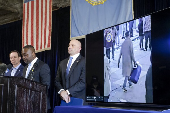 Lyonel Myrthil, special agent in charge of the New Orleans field office, second from left, shows footage of Shamsud-Din Jabbar, the man who carried out an attack on New Orleans' Bourbon Street on New Year's Day, during a news conference in a secure garage at the FBI Headquarters in New Orleans, Sunday, Jan. 5, 2025. (Scott Threlkeld/The Times-Picayune/The New Orleans Advocate via AP)