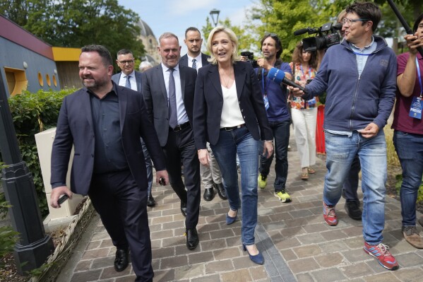 French far right leader Marine Le Pen, center, leaves after voting in the first round of the parliamentary election in Henin-Beaumont, northern France, Sunday, June 30, 2024. (AP Photo/Thibault Camus)