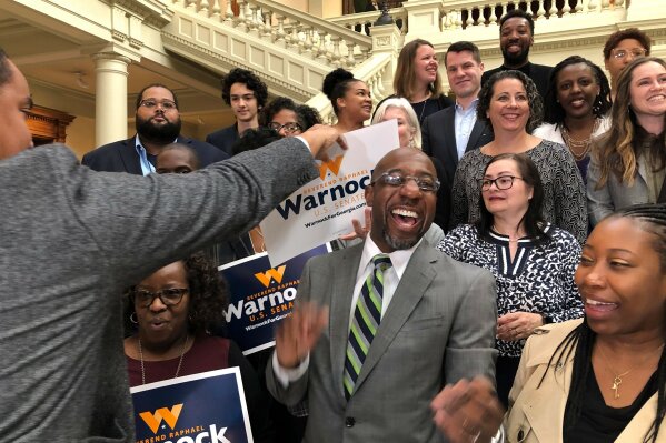 The Rev. Raphael Warnock, a Georgia Democrat, greets supporters at the state Capitol in Atlanta on Friday, March 6, 2020. Warnock filed paperwork to appear on the Nov. 3 ballot for Georgia’s special U.S. Senate election. (AP Photo/Benjamin Nadler)