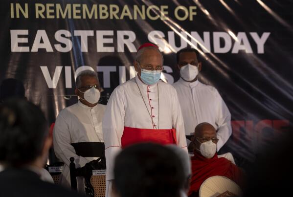 Cardinal Malcolm Ranjith, archbishop of Colombo, center, observes two minute silence for the victims of 2019 Easter Sunday attacks during a service at St. Anthony's Church in Colombo, Sri Lanka, Wednesday, April 21, 2021. Wednesday marked the second anniversary of the serial blasts that killed 269 people. (AP Photo/Eranga Jayawardena)