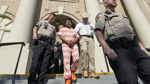 FILE - Francisco Oropeza, center, is escorted from the San Jacinto County courthouse by San Jacinto County Sheriff Greg Capers, second from right, after a hearing, May 18, 2023, in Coldspring, Texas. Oropeza, accused of killing five neighbors in Texas after some of them complained that gunfire was keeping a baby awake, was indicted Friday, June 30, on a capital murder charge that could carry the death penalty. (AP Photo/David J. Phillip, File)