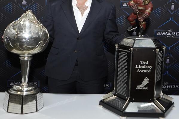 Toronto Maple Leafs center Auston Matthews poses with the Hart Trophy, left, and Ted Lindsay Award after the NHL hockey awards Tuesday, June 21, 2022, in Tampa, Fla. The Hart Trophy is presented annually to the leagues' most valuable player and the Ted Lindsay award is giving the the most outstanding player. (AP Photo/John Bazemore)