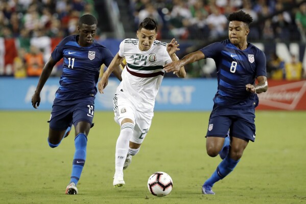FILE - Mexico midfielder Roberto Alvarado (24) dribbles the ball past U.S. midfielders Tim Weah (11) and Weston McKennie (8) during an international friendly match, Tuesday, Sept. 11, 2018, in Nashville, Tenn. Weston McKennie wants to prove he's worthy to Juventus and its fans. At Juventus, he's a teammate of fellow American Tim Weah, a son of Liberia President and former FIFA Player of the Year George Weah. (AP Photo/Mark Humphrey, File)