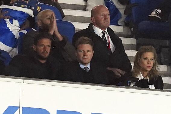 Former Bournemouth manager Eddie Howe, center, Newcastle United owner Amanda Staveley, right, and former Bournemouth assistant manager Jason Tindall sit in the stands during the English Premier League match between Brighton and Hove Albion and Newcastle United at the AMEX Stadium, Brighton, England, Saturday Nov. 6, 2021. (Gareth Fuller/PA via AP)