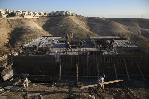 FILE - In this Feb. 7, 2017 file photo, Palestinian laborers work at a construction site in the Israeli settlement of Maale Adumim, near Jerusalem. International Criminal Court's decision authorizi...