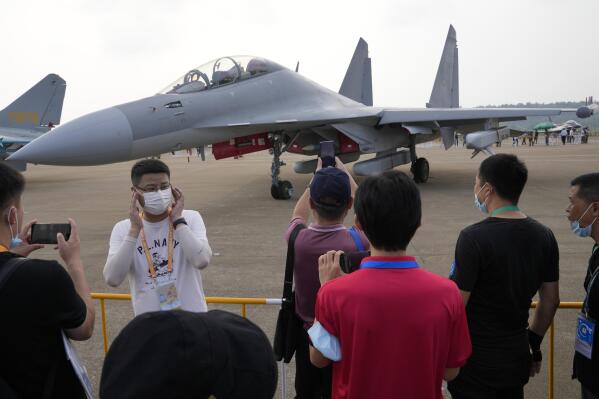 Visitors look at the Chinese military's J-16D electronic warfare airplane during 13th China International Aviation and Aerospace Exhibition, also known as Airshow China 2021, on Wednesday, Sept. 29, 2021, in Zhuhai in southern China's Guangdong province. China flew 39 warplanes, including 24 J-16s and 10 J-10s, toward Taiwan, Sunday, Jan. 23, 2022, in its largest such sortie of the new year, continuing a pattern that the island has answered by scrambling its own jets in response. (AP Photo/Ng Han Guan)