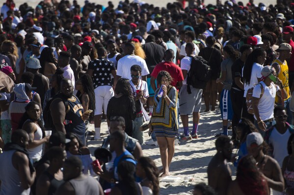 FILE - A woman sips on her drink inside the crowd of party-goers during Orange Crush on Tybee Island, Ga., April 16, 2016. Thousands of Black college students expected this weekend for an annual spring bash at Georgia's largest public beach shouldn't expect a warm welcome. Tybee Island's city leaders are bringing in dozens of extra police officers and using barricades to block parking lots and residential streets during Orange Crush, a sprawling beach party begun three decades ago. (Josh Galemore/Savannah Morning News via AP, File)