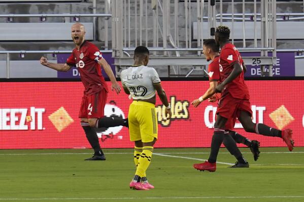 Toronto FC midfielder Michael Bradley (4) celebrates with teammates after scoring a goal against the Columbus Crew as Columbus Crew midfielder Luis Diaz (12) walks away during the first half of an MLS soccer match, Wednesday, May 12, 2021, in Orlando, Fla. (AP Photo/John Raoux)