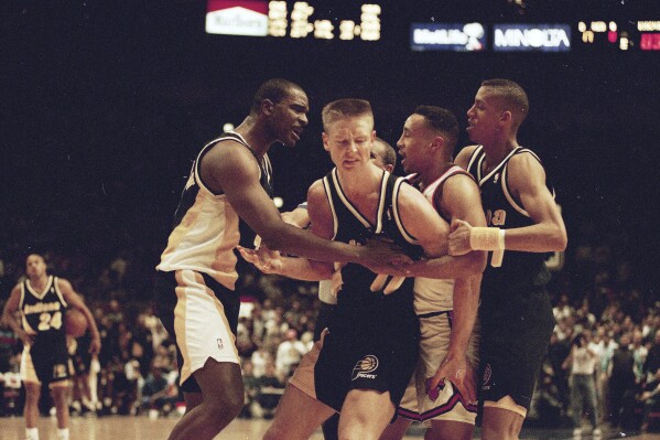 Indiana Pacers' Detlef Schrempf, center, is restrained by teammate LaSalle Thompson, left, as New York Knicks' John Starks, second from right, is sandwiched between the Pacers' Reggie Miller during a third period scuffle that began when Schrempf clashed with Knicks' Anthony Mason in New York's Madison Square Garden, March 15, 1993. The Knicks went on to a 121-90 win. (AP Photo/Bill Koustroun, File)