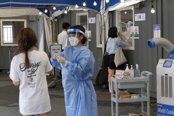 Medical workers takes nasal samples from residents for coronavirus tests at a makeshift testing site in Seoul, South Korea, Tuesday, July 20, 2021. (AP Photo/Ahn Young-joon)