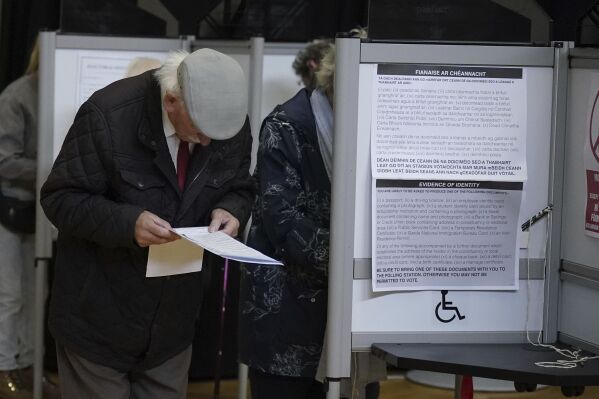 A man looks at the ballot papers before casting his vote in the local and European elections at the Deaf Village in Dublin, Ireland, Friday June 7, 2024. (Niall Carson/PA via AP)
