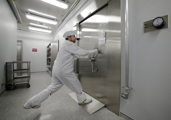 Jeremy Kent, Apollo sample curation processor, tugs to open the 1978 U.S. federal bank vault that protects the entrance to the lunar sample vault inside the lunar lab at the NASA Johnson Space Center Monday, June 17, 2019, in Houston. The door requires two separate combinations, held by two separate people, to open. (AP Photo/Michael Wyke)